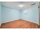 Bedroom with light blue painted walls, wood-look flooring and a window with a roller shade at 2446 S Vaughn Way # A, Aurora, CO 80014