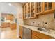 Elegant butler pantry with granite countertops, under-cabinet beverage fridge, and glass-front cabinets at 3806 S Dawson St, Aurora, CO 80014