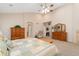 A large main bedroom with plush carpet, vaulted ceiling, and wooden dressers with ensuite access to the bathroom at 3806 S Dawson St, Aurora, CO 80014