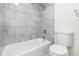 Bright bathroom features a tiled shower and tub with modern fixtures, alongside a white toilet at 1519 S Sable Blvd # C, Aurora, CO 80012