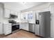 Well-lit kitchen featuring white cabinets, stainless steel appliances, granite countertops and hardwood floors at 1519 S Sable Blvd # C, Aurora, CO 80012