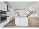 Modern kitchen with white cabinets, stainless steel appliances, and a large island at 3372 N Buchanan Way, Aurora, CO 80019