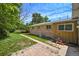 Brick and wood exterior with a paved patio area and a lawnmower at 6432 Zephyr St, Arvada, CO 80004