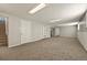 Expansive finished basement with carpeting, recessed lighting, and built in shelving at 6432 Zephyr St, Arvada, CO 80004