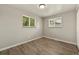 This bedroom is illuminated with two picture windows and wood-look floors at 6432 Zephyr St, Arvada, CO 80004