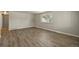 Neutral bedroom features wood-look floors, baseboard heating, and large picture window at 6432 Zephyr St, Arvada, CO 80004