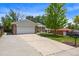 Brick home with front lawn, driveway, and large shade tree offers great curb appeal at 6432 Zephyr St, Arvada, CO 80004