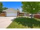 Charming brick home featuring an attached two-car garage and well-maintained front yard landscaping at 6432 Zephyr St, Arvada, CO 80004