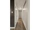 Hallway with wood-look flooring, neutral paint, baseboard trim, and overhead lighting at 6432 Zephyr St, Arvada, CO 80004