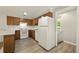 Kitchen with wood cabinets, updated appliances, and modern flooring at 6432 Zephyr St, Arvada, CO 80004