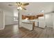 Open concept living area with wood flooring, kitchen, and ample natural light at 6432 Zephyr St, Arvada, CO 80004