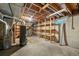 Exposed, unfinished basement area with wood framing, concrete walls, and storage shelves at 6432 Zephyr St, Arvada, CO 80004