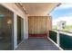 View of the wood-floored balcony of the house with a light colored screen and a sliding glass door at 1121 Albion St # 809, Denver, CO 80220