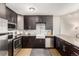 Well-lit kitchen features stainless steel appliances, dark wood cabinets, and a modern countertop at 1121 Albion St # 809, Denver, CO 80220