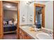 Bathroom with double sinks, wood cabinets, and a view into the bedroom at 180 Emmett Lode Rd, Breckenridge, CO 80424
