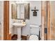 Rustic bathroom featuring pedestal sink, unique mirror and wood accents at 180 Emmett Lode Rd, Breckenridge, CO 80424