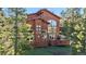 Beautiful home with a large deck surrounded by lush greenery and trees at 180 Emmett Lode Rd, Breckenridge, CO 80424