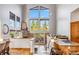 Bright living room with tall windows offering scenic views, stone fireplace, and seamless access to the kitchen at 180 Emmett Lode Rd, Breckenridge, CO 80424