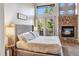 Vaulted ceiling main bedroom features stone fireplace and access to outdoor deck at 180 Emmett Lode Rd, Breckenridge, CO 80424