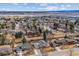 Neighborhood aerial showcasing the area's houses, mature trees, and a distant view of mountains at 7310 S Sheridan Ct, Littleton, CO 80128