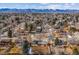 An aerial view of the neighborhood with houses, mature trees, and a backdrop of mountain peaks at 7310 S Sheridan Ct, Littleton, CO 80128