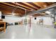 Spacious unfinished basement with exposed wooden beams, concrete floor, and potential for customization at 7310 S Sheridan Ct, Littleton, CO 80128