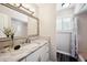 Bright bathroom featuring marble countertop, modern vanity, large mirror, and a shower-tub combination at 7310 S Sheridan Ct, Littleton, CO 80128