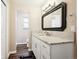 Bathroom with white cabinets, marble counters, modern fixtures, and stylish decor at 7310 S Sheridan Ct, Littleton, CO 80128