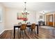 Open dining room area with wood floors and modern chandelier lighting fixture at 7310 S Sheridan Ct, Littleton, CO 80128