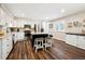 Beautiful kitchen boasts white cabinetry, a dark island with seating, stainless steel appliances, and modern finishes at 7310 S Sheridan Ct, Littleton, CO 80128