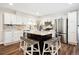 Updated kitchen features white cabinets, stainless steel appliances, a dark island with seating, and stylish countertops at 7310 S Sheridan Ct, Littleton, CO 80128