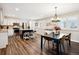 Bright, open kitchen and dining area with stainless steel appliances, a kitchen island, and modern lighting fixtures at 7310 S Sheridan Ct, Littleton, CO 80128