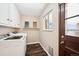 Functional laundry area with modern washer and dryer, wood-look flooring, and organized shelving at 7310 S Sheridan Ct, Littleton, CO 80128