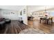 Open-concept living room boasts wood-look flooring, leading to a dining area and creating a seamless flow at 7310 S Sheridan Ct, Littleton, CO 80128