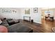 Comfortable living room boasts wood-look flooring, stylish decor, and a view of the dining area for easy entertaining at 7310 S Sheridan Ct, Littleton, CO 80128