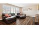 Comfortable living room showcases a sectional sofa, wood-look flooring, and plantation shutters for a cozy ambiance at 7310 S Sheridan Ct, Littleton, CO 80128