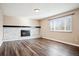 Bright living room with painted brick fireplace, mantle and large windows at 7310 S Sheridan Ct, Littleton, CO 80128