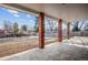 Covered patio area with brick columns overlooking a spacious backyard with some snow remnants at 7310 S Sheridan Ct, Littleton, CO 80128
