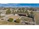 Aerial shot of horse property with a fenced paddock, barn, mature trees, and nearby residences at 15935 W 77Th Pl, Arvada, CO 80007