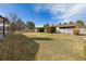 Spacious backyard with healthy lawn, decorative bushes, a white fence, and mature trees under a blue sky at 15935 W 77Th Pl, Arvada, CO 80007