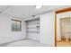 Basement featuring storage shelves, a window, carpeted floors, and a partially visible bathroom at 15935 W 77Th Pl, Arvada, CO 80007