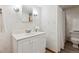 Bathroom featuring wallpaper, single sink vanity, and a shower behind a white curtain at 15935 W 77Th Pl, Arvada, CO 80007