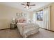 Bright bedroom featuring a ceiling fan, window, and upholstered headboard with matching side tables at 15935 W 77Th Pl, Arvada, CO 80007
