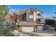 Beautiful two-story home with a brick and white facade, a two-car garage, and a professionally landscaped yard at 15935 W 77Th Pl, Arvada, CO 80007