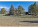 Manicured front yard with mature trees and landscaping leads to an inviting home with lots of space at 15935 W 77Th Pl, Arvada, CO 80007