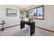 Bright home office with large windows, a modern desk, and neutral carpeting for a comfortable workspace at 15935 W 77Th Pl, Arvada, CO 80007