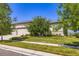 Charming stucco home with a manicured lawn, mature trees, and a three-car garage under a blue sky at 15975 Quandary Loop, Broomfield, CO 80023