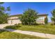 Well-maintained, stucco home with a manicured lawn, mature tree, and a three-car garage at 15975 Quandary Loop, Broomfield, CO 80023