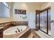 Soothing main bathroom with soaking tub, glass-enclosed shower, and tile flooring, perfect for relaxation at 15975 Quandary Loop, Broomfield, CO 80023