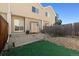 Backyard features grass, rock area, and concrete patio with sliding door to the home at 7234 E 38Th Ave, Denver, CO 80207